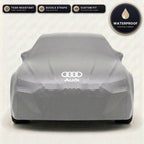 Gray Audi outdoor car cover, waterproof and custom fit, with printed Audi logo