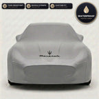 Gray Maserati outdoor car cover, waterproof and custom fit, with printed Maserati logo